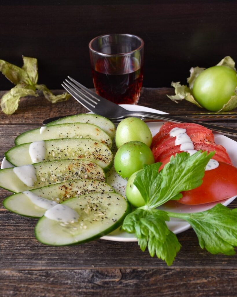 A white plate topped with cucumbers and tomatoes