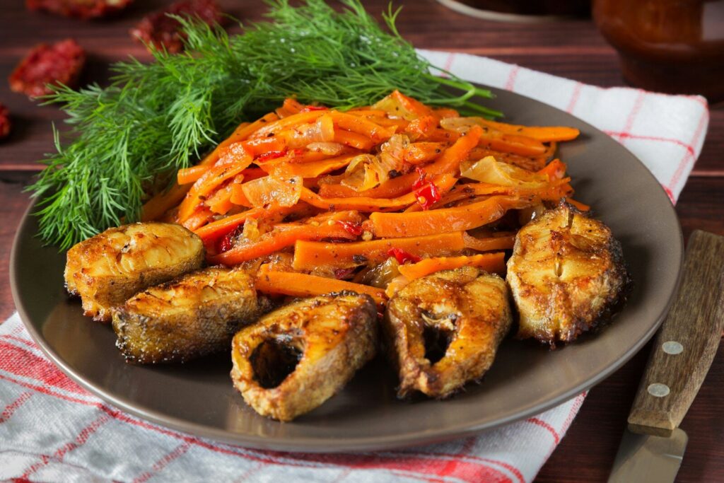 Fried fish with stewed carrots and dill